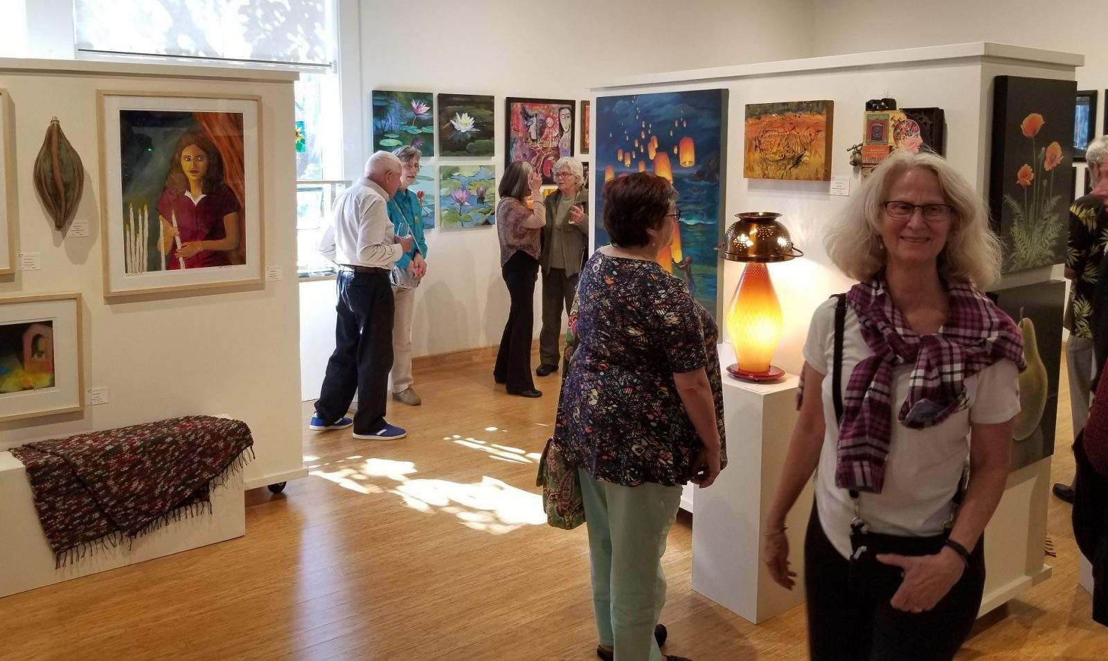Colorful gallery reception with people looking at art