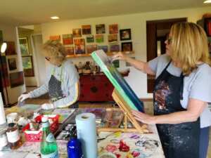 Lynne Wintermute working in their studio on a painting